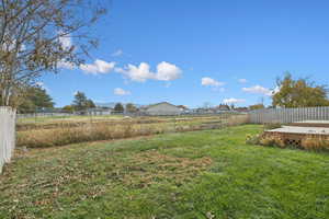 Fenced backyard featuring a view of countryside