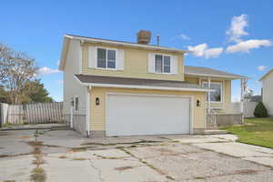 View of front facade featuring an attached garage, concrete driveway, and a shingled roof