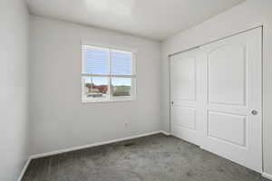 Unfurnished bedroom with carpet and a closet