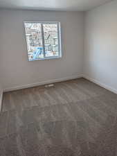 Spare room featuring carpet flooring and a textured ceiling