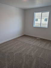 Empty room featuring carpet floors and a textured ceiling