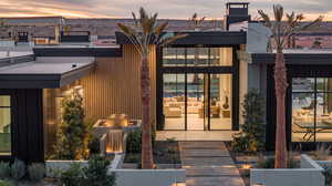 Exterior entry at dusk featuring a chimney