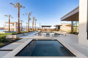 Outdoor pool featuring a patio area, an in-ground hot tub, and a water and mountain view