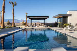 View of pool featuring a mountain view, a fenced backyard, and a patio