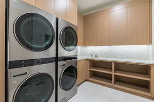 Washroom featuring a sink and stacked washer / drying machine