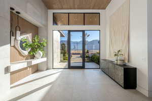 Entryway with a mountain view, wooden ceiling, a high ceiling, and tile patterned flooring