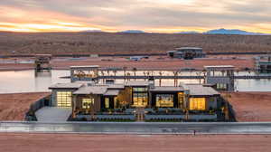 Back of property at dusk featuring a water and mountain view