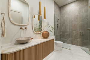 Full bath featuring double vanity and a stall shower