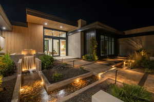 Back of house at twilight with a patio area