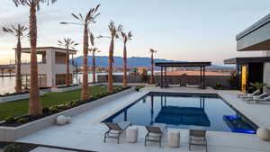 View of swimming pool featuring a water and mountain view, a patio, and a fenced backyard