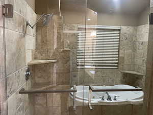 Full bathroom with a whirlpool tub and tiled shower