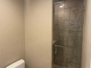 Bathroom with a shower stall and toilet