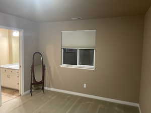 Unfurnished bedroom featuring light colored carpet and ensuite bath