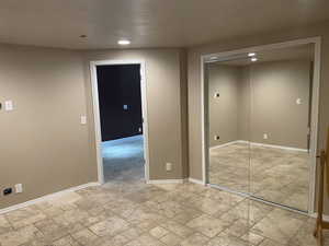 Empty room with stone tile floors and recessed lighting