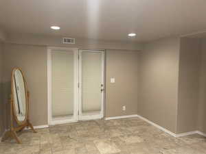 Unfurnished room featuring stone finish flooring and recessed lighting