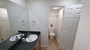 Half bath with vanity and light wood-style flooring