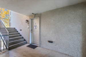 View of exterior entry featuring stucco siding and crawl space