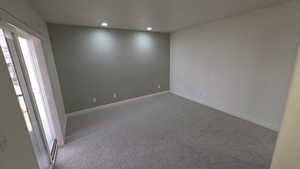 Carpeted spare room with recessed lighting and baseboards