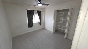Unfurnished bedroom featuring ceiling fan and light carpet