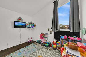 Rec room featuring dark wood finished floors and lofted ceiling