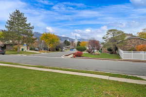 View of asphalt street featuring a mountain view, curbs, and sidewalks