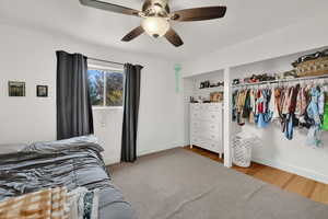 Bedroom featuring wood finished floors, a closet, and a ceiling fan