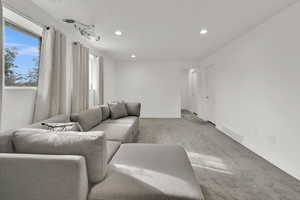 Living area with carpet and recessed lighting