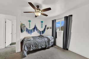 Carpeted bedroom featuring baseboards and a ceiling fan