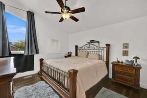 Bedroom featuring lofted ceiling, dark wood-style flooring, and a ceiling fan