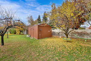 Fenced backyard featuring a shed