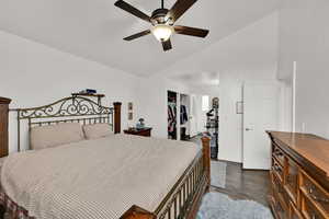Bedroom featuring a closet, dark wood finished floors, ceiling fan, and high vaulted ceiling