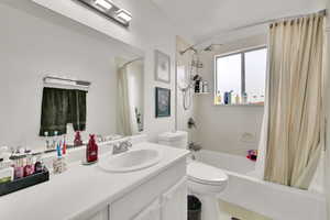 Bathroom with shower / tub combo with curtain, vanity, and tile patterned floors