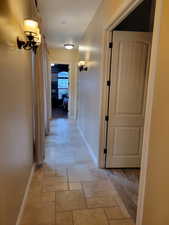Corridor with baseboards and stone tile flooring
