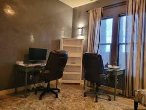 Office space featuring light wood-style floors and a textured wall