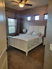 Bedroom featuring dark carpet and a ceiling fan