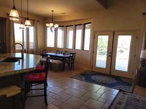 Dining room featuring stone tile flooring, healthy amount of natural light, and french doors