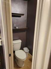 Bathroom with toilet and light tile patterned flooring