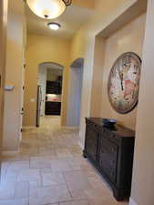 Hallway with arched walkways and stone tile flooring