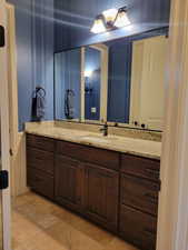 Bathroom featuring vanity and light stone finish floors