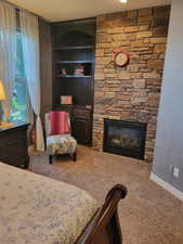 Bedroom with carpet floors and a fireplace