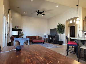 Living area featuring a stone fireplace, ceiling fan, recessed lighting, and arched walkways