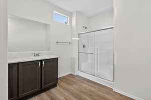 Full bath featuring vanity, light wood-type flooring, and a stall shower