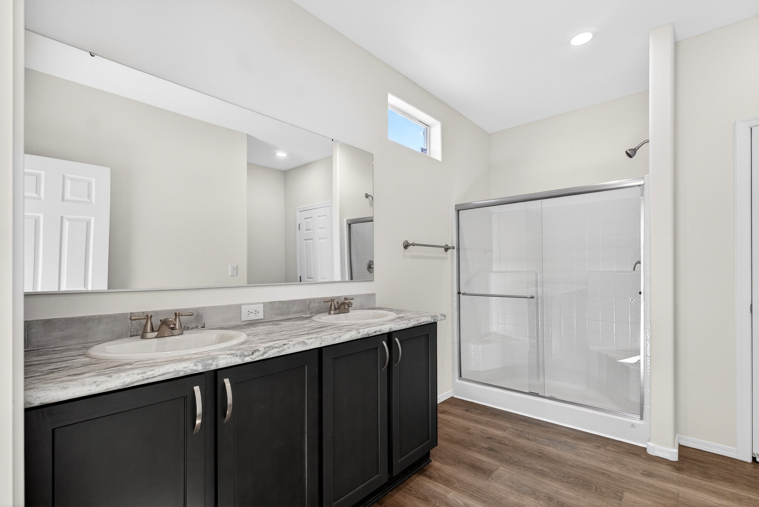 Full bathroom with double vanity, a stall shower, dark wood-style floors, and recessed lighting