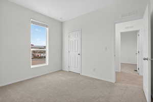 Unfurnished bedroom with light carpet