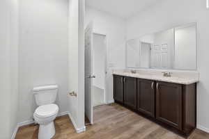 Full bathroom featuring double vanity and light wood-style flooring