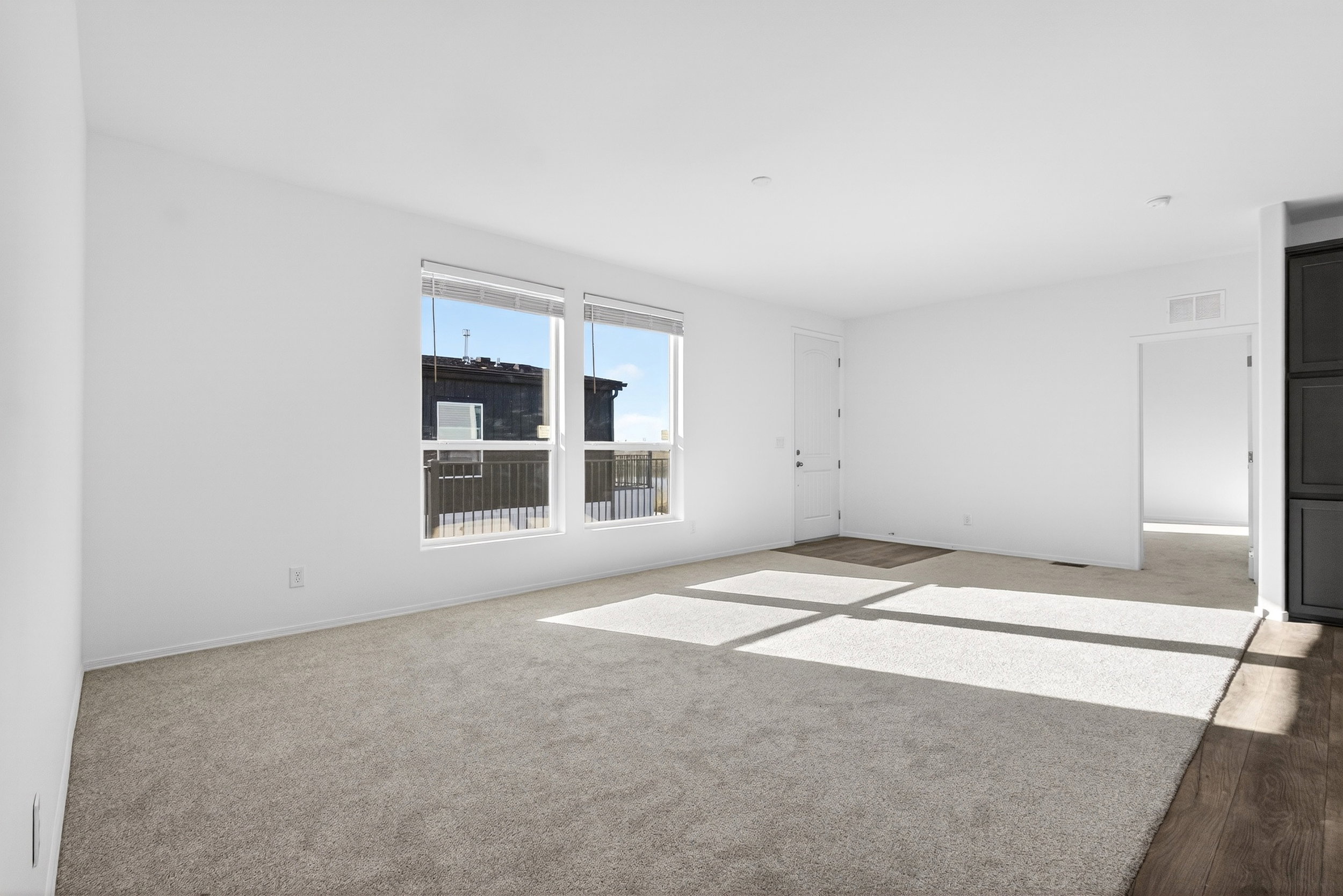 Spare room with light colored carpet and light wood-style floors
