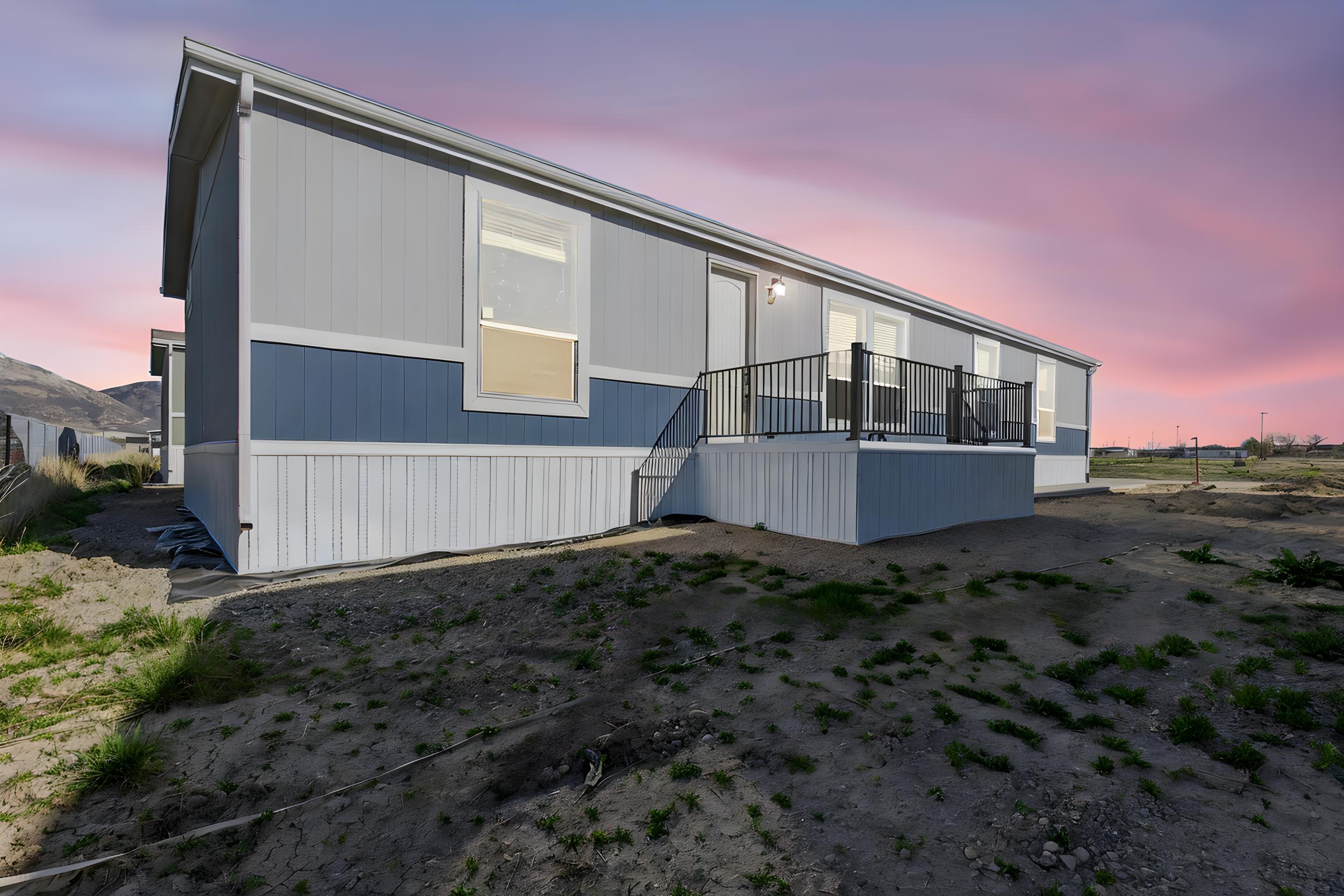 Back of house at dusk with a wooden deck