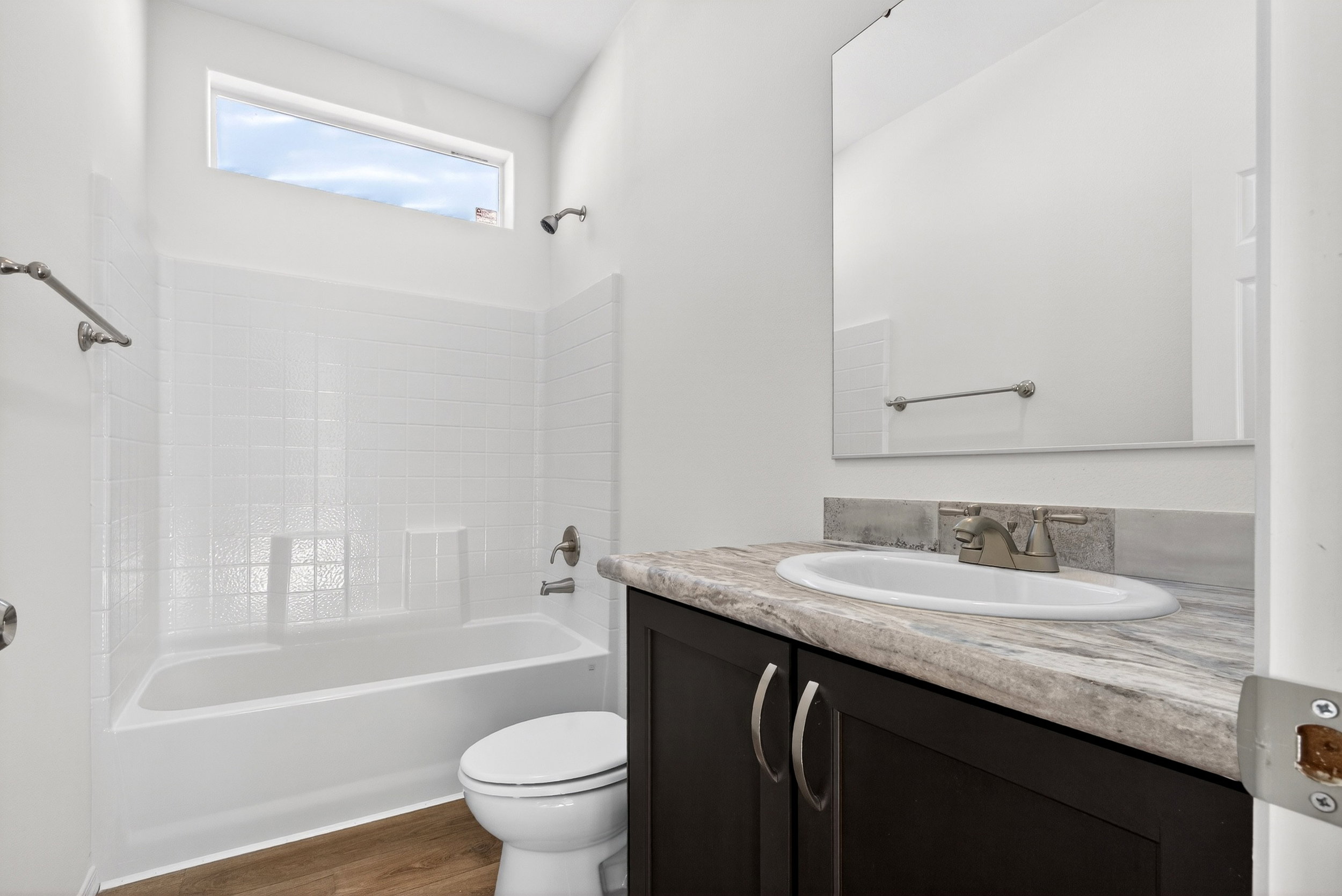 Full bathroom with vanity, bathtub / shower combination, and dark wood-type flooring