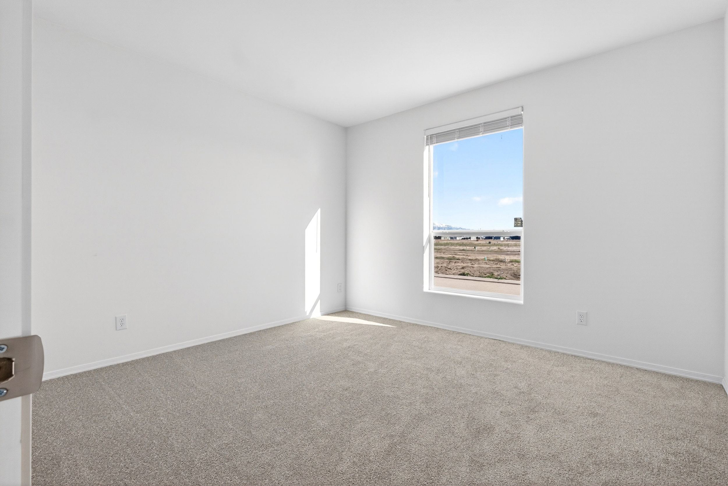 Spare room featuring carpet and baseboards