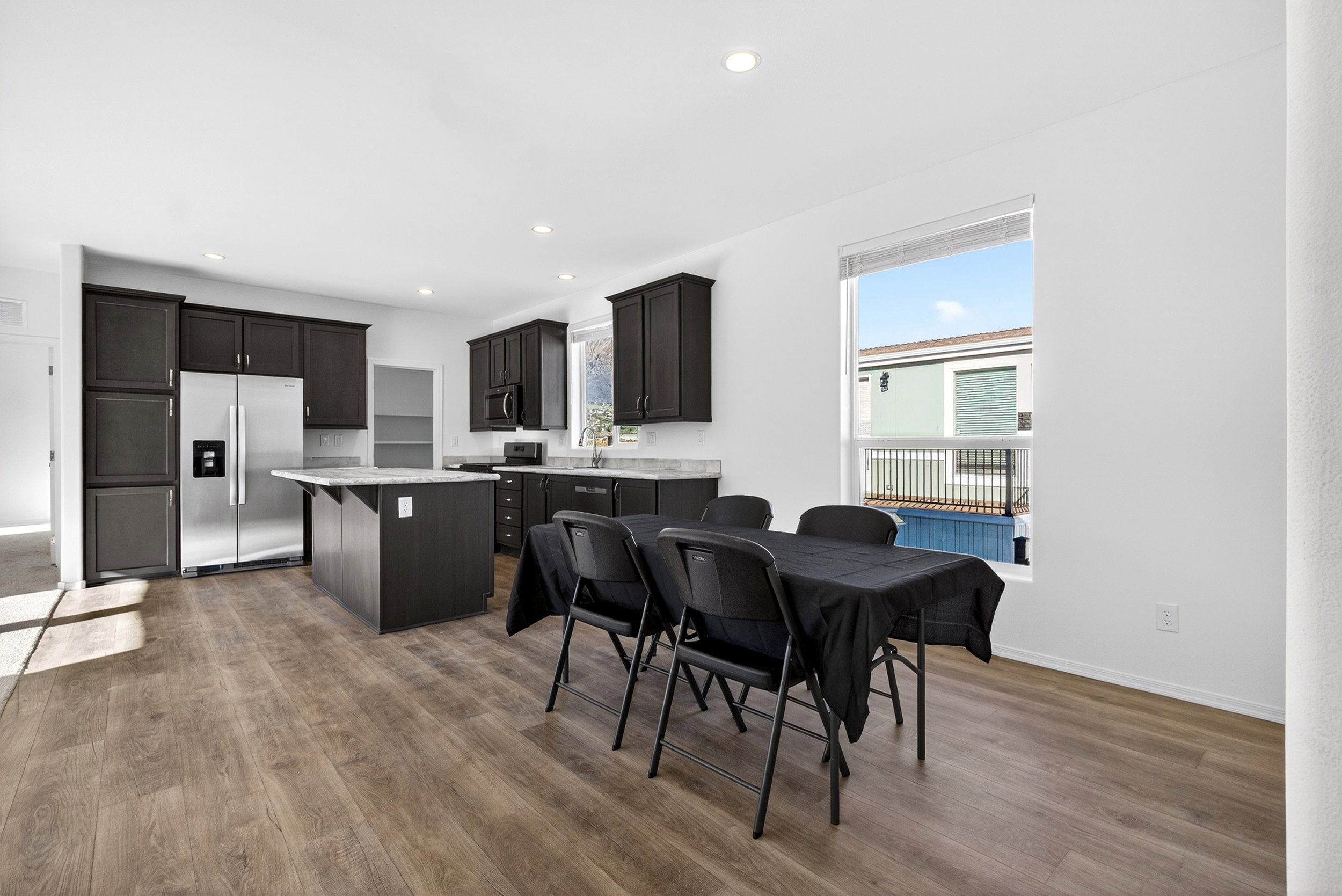Dining room with dark wood-type flooring and recessed lighting
